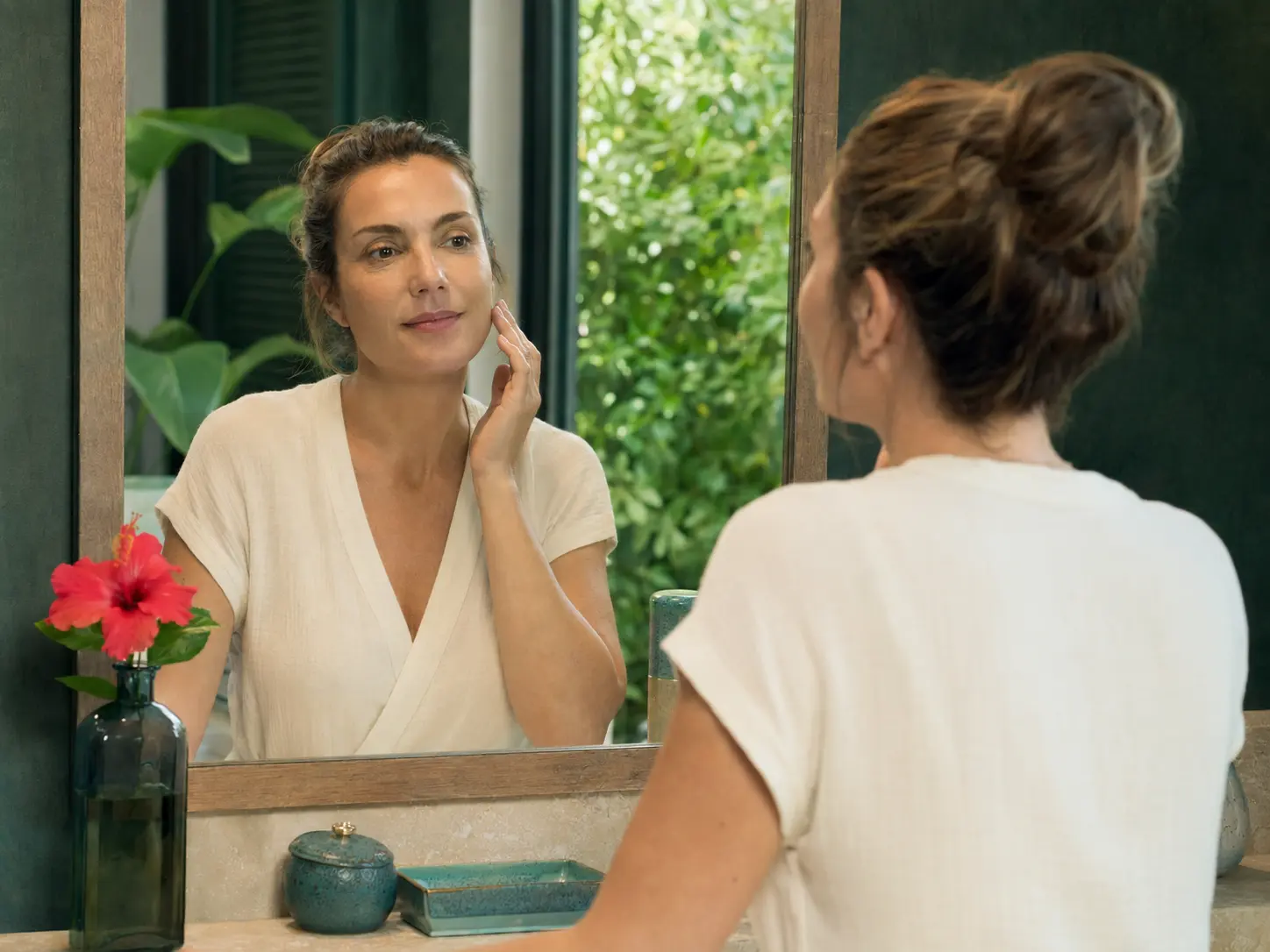 Une femme devant un miroir pendant un rituel de beauté